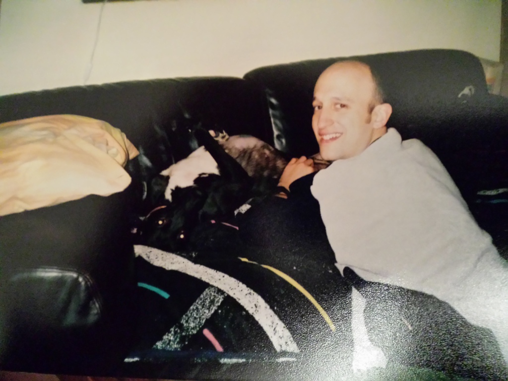 Ally laying on her back on their sofa, enjoying a tummy tickle.